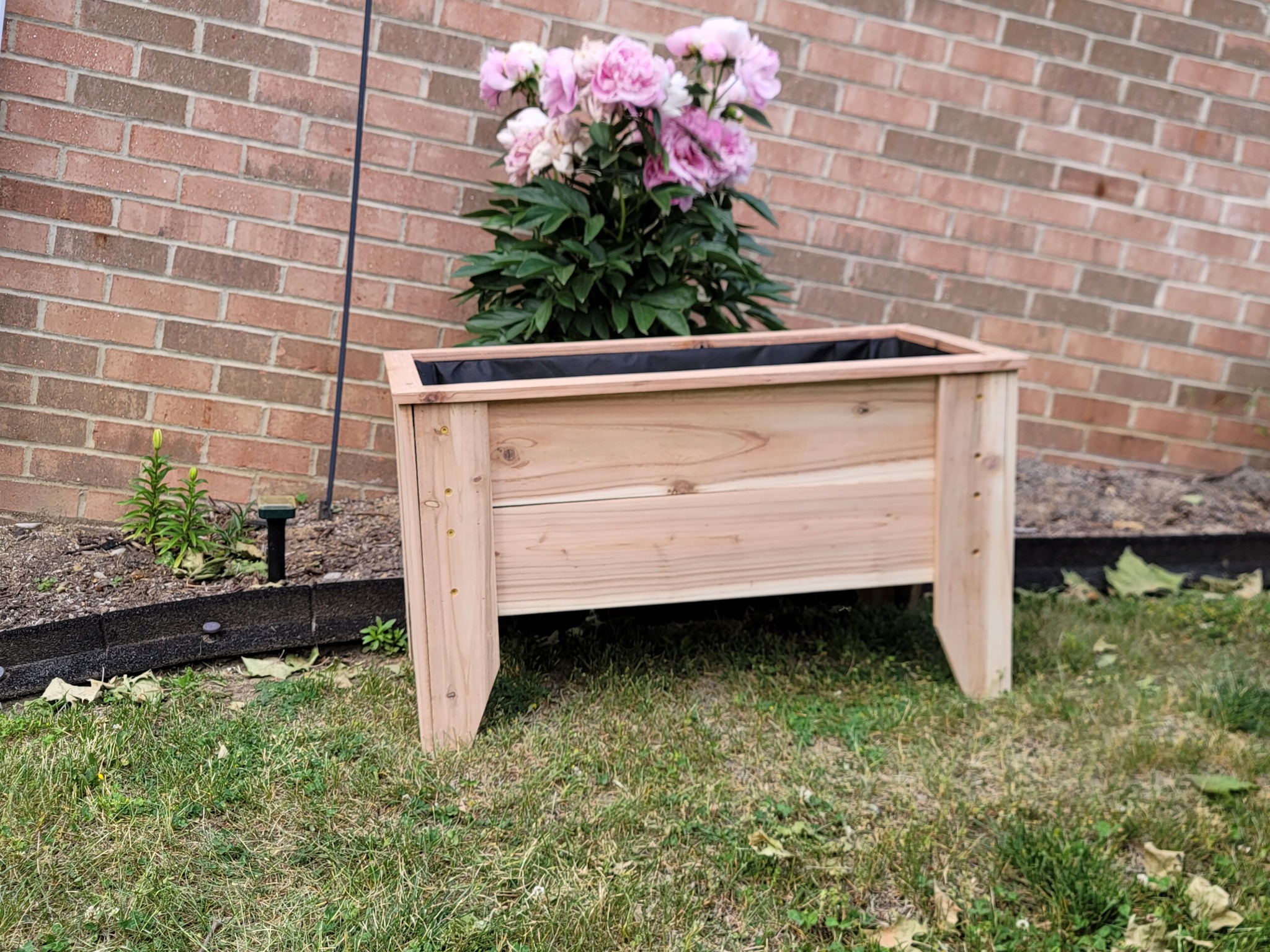 Handmade raised wooden planter box with flowers